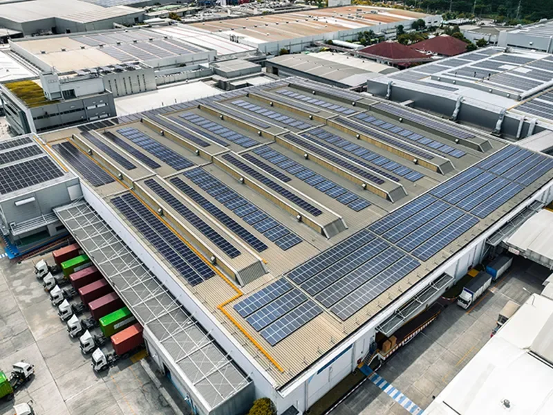 Vista aérea de una nave industrial con instalación de paneles solares en cubierta para autoconsumo energético y reducción de costes empresariales
