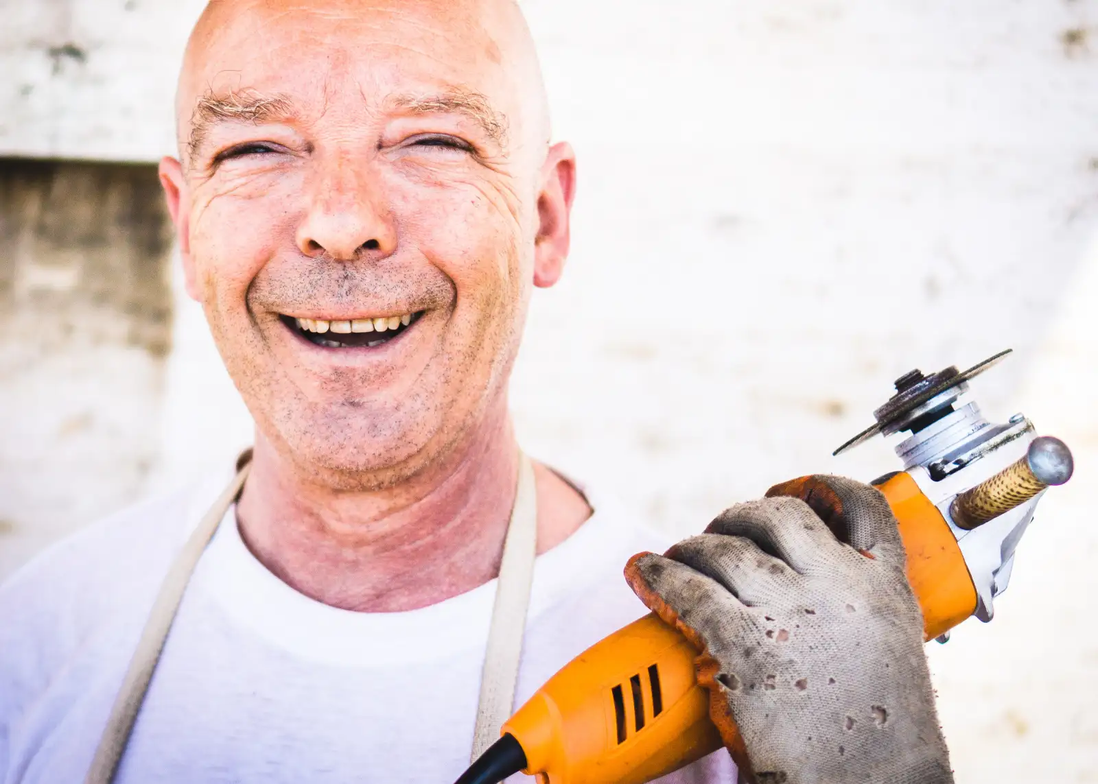 TRABAJADOR-METAL Tipo feliz con su máquina en la mano