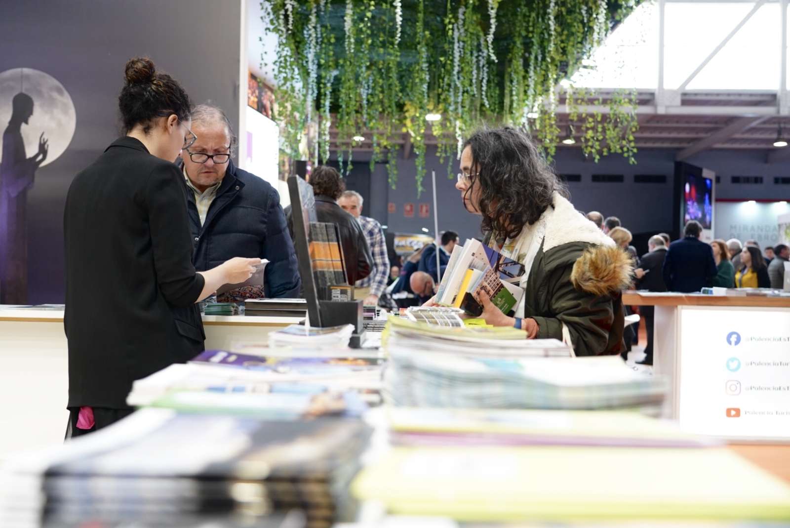 Feria donde una joven se interesa por un expositor Feria donde una joven se interesa por un expositor